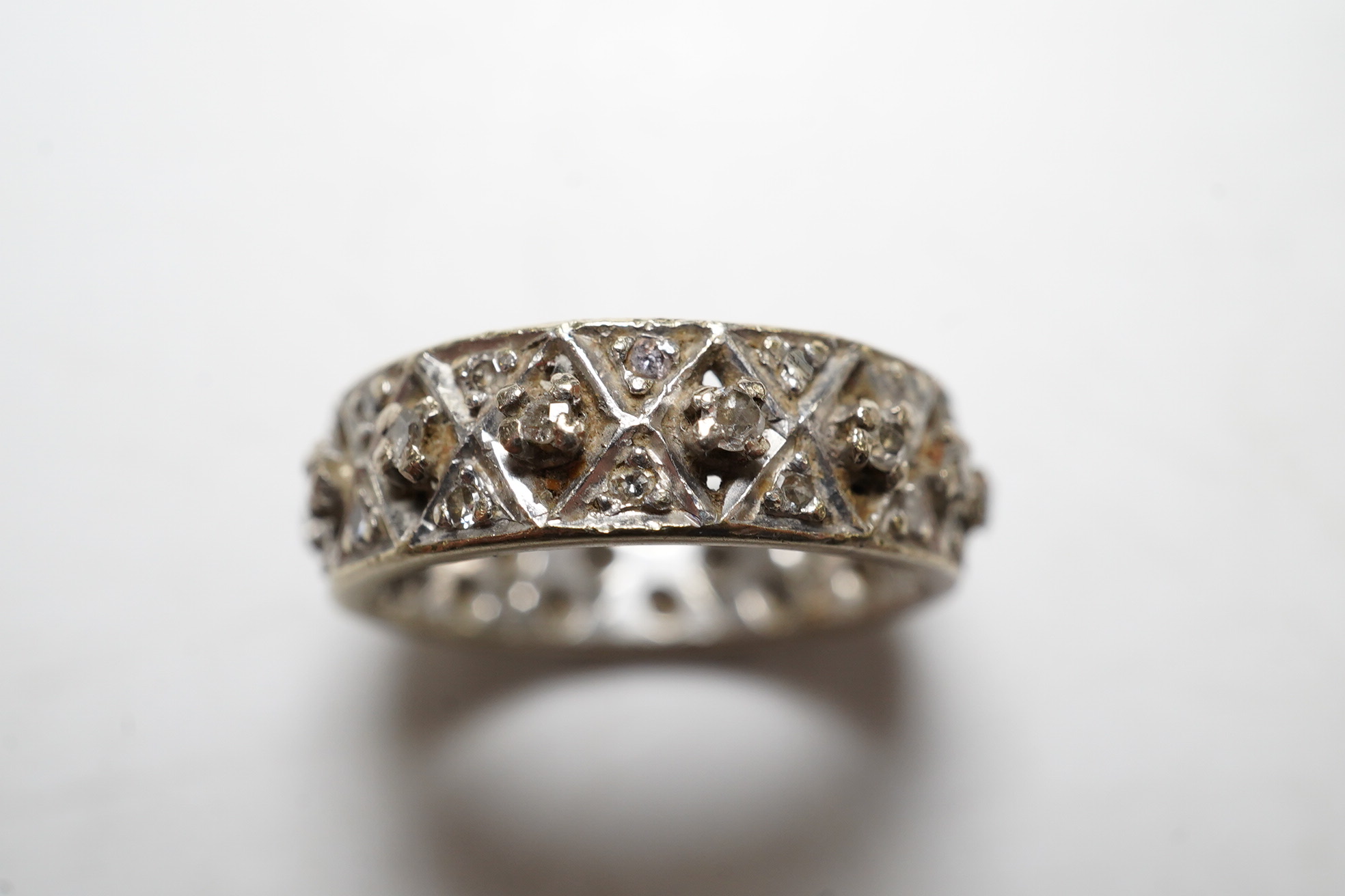 A diamond set white gold full eternity ring, size J, gross 4.7 grams. Condition - wear to the edges and one stone missing